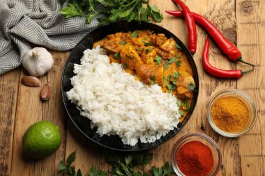 Tavuklu tikka masala, pirinç ve baharatlar ahşap masada, düz yerde.