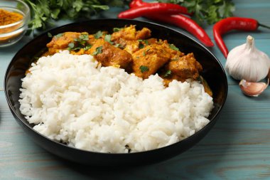 Pirinç ve baharatlı tavuk tikka masala açık mavi ahşap masa, yakın plan