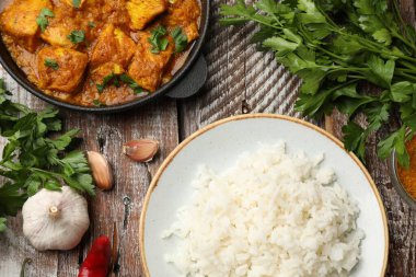 Tavuklu tikka masala, pirinç ve baharatlar ahşap masada, düz yerde.