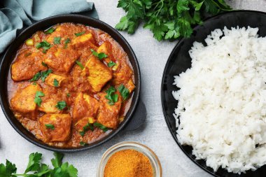 Gri masada pirinç ve baharatlı tavuk tikka masala.