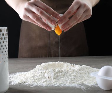 Ahşap masada yumurta kıran kadın, yakın plan.