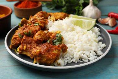 Pirinç, maydanoz, kireç ve baharatlı leziz tavuk tikka masala açık mavi ahşap masa, yakın plan