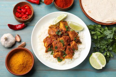 Pirinç, maydanoz, kireç ve baharatlı leziz tavuk tikka masala açık mavi ahşap masa, düz yatıyordu