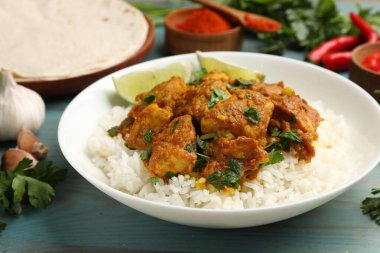 Pirinç, maydanoz, kireç ve baharatlı leziz tavuk tikka masala açık mavi ahşap masa, yakın plan
