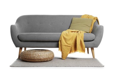 Gri kanepe, yastık, battaniye, halı ve hasır puf beyaza izole edilmiş.