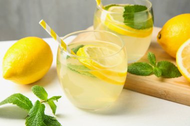 Taze limonata, limon ve nane şekeri beyaz masada, yakın plan.