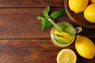 Mason kavanozunda taze limonata, ahşap masada limon ve nane. Metin için boşluk