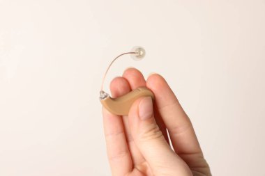 Işıklı arka planda işitme cihazı olan kadın, yakın plan