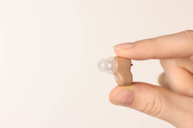 Hafif arka planda işitme cihazı olan kadın, yakın plan. Metin için boşluk