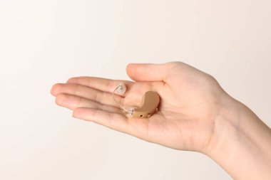 Işıklı arka planda işitme cihazı olan kadın, yakın plan