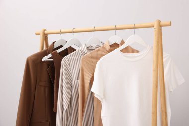 İçerideki duvarın yanındaki askıda asılı farklı şık kıyafetler.