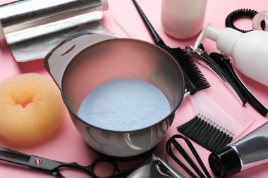 Pembe arka planda saç boyama için profesyonel araçlar ve ürünler, yakın plan