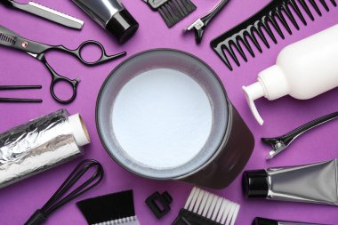 Mor arka planda saç boyama için profesyonel araçlar ve ürünler, düz yatış