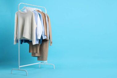 Açık mavi arkaplanda asılı farklı giysiler, metin için boşluk