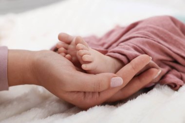 Anne yeni doğmuş bebeğiyle yatakta, yakın plan.