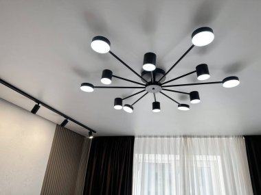 Odanın beyaz tavanında şık bir avize.