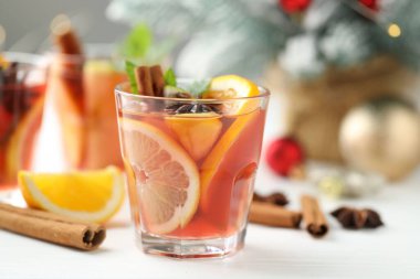 Lezzetli punç bardaklar, baharatlar ve Noel dekorları beyaz ahşap masa, yakın plan
