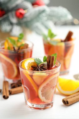 Bardaklarda, baharatlarda ve Noel dekoru beyaz masada, yakın plan.