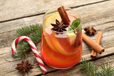 Bardakta kokteyl, baharat ve Noel süsü, ahşap masada, yakın plan.