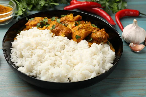Pirinç ve baharatlı tavuk tikka masala açık mavi ahşap masa, yakın plan