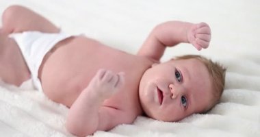 Bebek bezli şirin bebek yatakta uzanıyor, yakın plan.