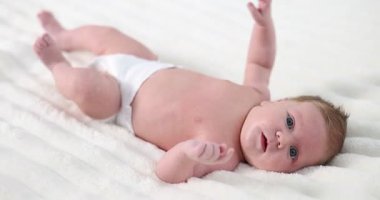 Bebek bezli tatlı bebek yatakta yatıyor. Kamera ileri gidiyor