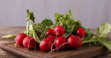 Tahta masadaki taze turplara su püskürtüyor, yakın plan.