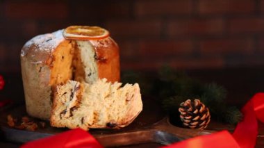 Noel yemeği. Lezzetli Panettone pastası ve ahşap masada şenlikli bir dekor, yakın plan. Kamera sola hareket ediyor