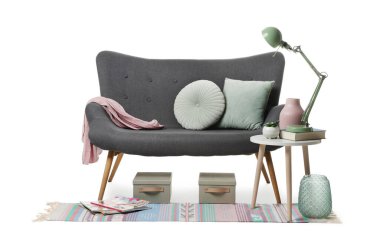 Şık bir kanepe, lamba, sehpa, dekorasyon ve beyaz arka planda halı.