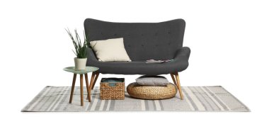 Gri kanepe, yastıklar, yan masa, depolama sepeti ve puf beyaza izole edilmiş.