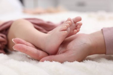 Anne yeni doğmuş bebeğiyle evde, yatakta, yakın plan.