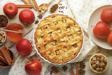 Lezzetli ev yapımı elmalı turta ve beyaz mermer masa üzerindeki malzemeler, düz uzanmış.