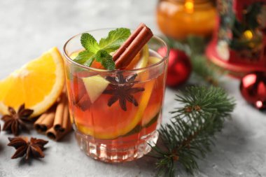 Lezzetli punç içeceği, baharatlar ve Noel dekoru ışık masasında, yakın plan.