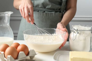 Beyaz masada hamuru hazırlayan kadın, yakın plan.