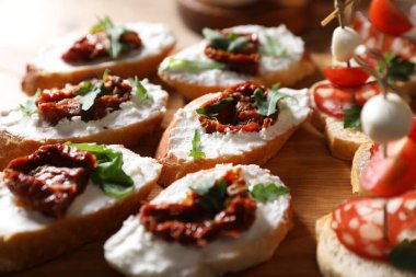Farklı lezzetli bruschettalar ahşap masada, yakın plan