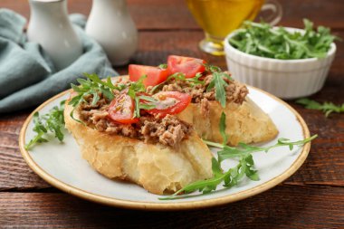 Lezzetli bruschettalar, ton balığı, domates ve roka, ahşap masa, yakın plan.