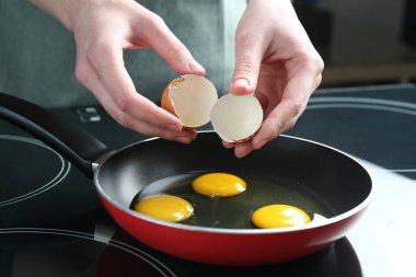 Mutfakta yumurta kıran bir kadın, yakın plan.