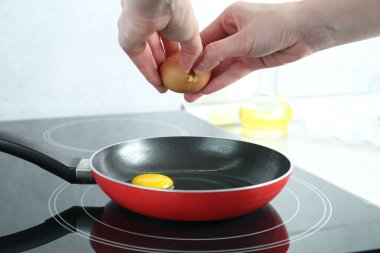 Mutfakta yumurta kıran bir kadın, yakın plan.