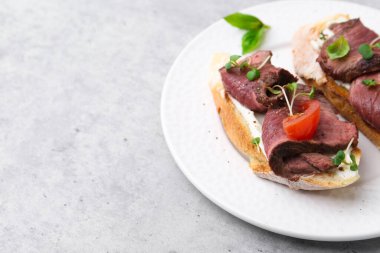 Hafif masada servis edilen biftekli nefis bruschetalar, yakın plan. Metin için boşluk