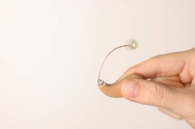 Hafif arka planda işitme cihazı olan kadın, yakın plan. Metin için boşluk