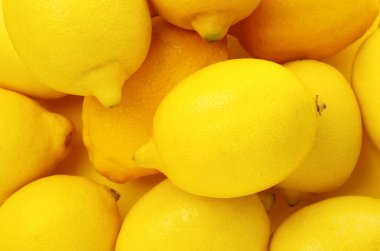 Sarı arka planda taze limonlar, düz uzanmış.