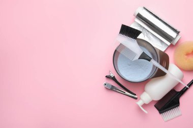 Profesyonel aletler ve pembe arka planda saç boyama ürünleri, düz yatak. Metin için boşluk