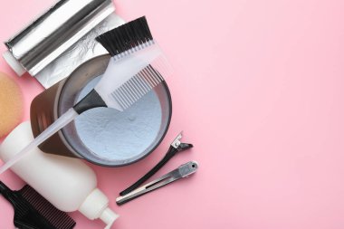 Profesyonel aletler ve pembe arka planda saç boyama ürünleri, düz yatak. Metin için boşluk