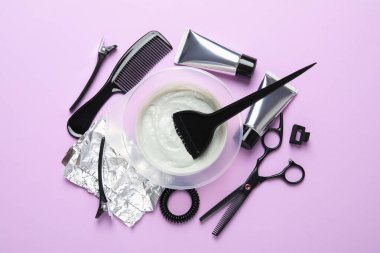 Mor arka planda saç boyama için profesyonel araçlar ve ürünler, düz uzanma