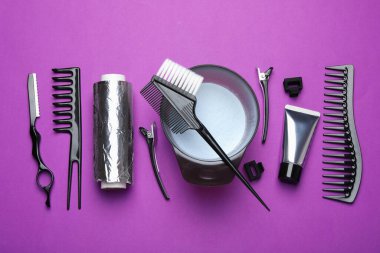 Mor arka planda saç boyama için profesyonel araçlar ve ürünler, düz yatış