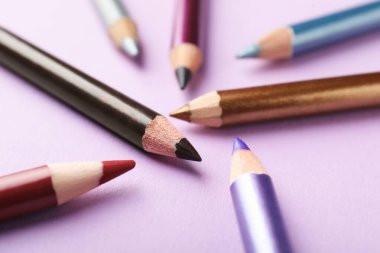 Pembe arka planda renkli göz kalemleri, yakın plan.