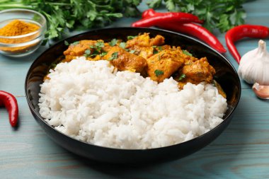 Pirinç ve baharatlı tavuk tikka masala açık mavi ahşap masa, yakın plan