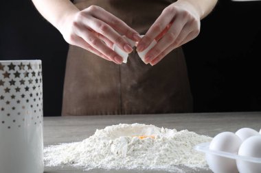 Ahşap masada yumurta kıran kadın, yakın plan.