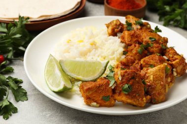 Pirinç, maydanoz ve limonlu leziz tavuk tikka masala. Gri desenli masa, yakın plan.