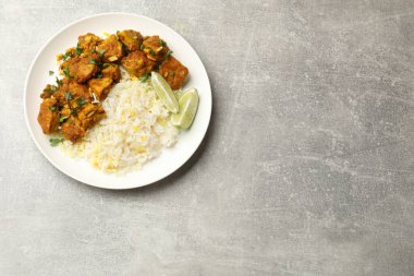 Pirinçli tavuk tikka masala, maydanoz ve limonlu gri desenli masa, üst manzara. Metin için boşluk